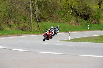 Kurvenwahn, zwei sportliche Motorradfahrer schneiden Linkskurve