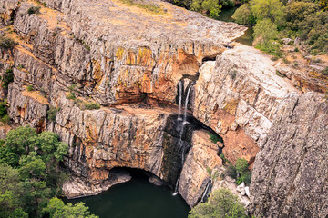 Cascada de agua sobre piedra caliza en La Cimbarra de Aldeaquemada