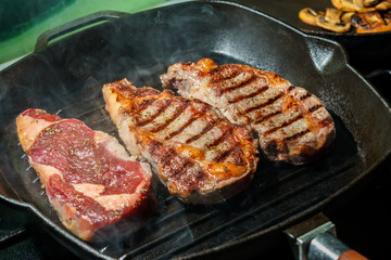 Raw Ribeye Steak with Herbs and Spices, frying on grill pan