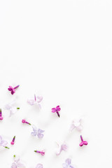 white background on a half filled with lilac flowers. Concept of freshness and beautifulness. Flat lay. Top view. empty spase for the text.