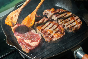 Raw Ribeye Steak with Herbs and Spices, frying on grill pan