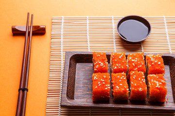 Rolls, soy sauce, chopsticks on table