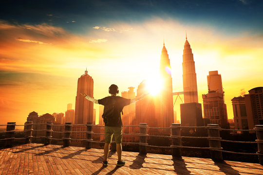 Silhouette man raise hands up for him success, beautiful cityscapes skyline view. morning sunrise scene .