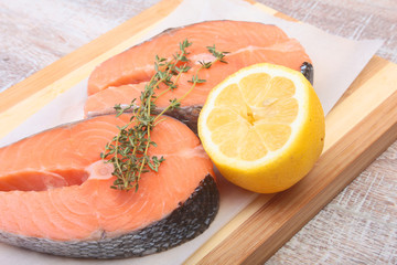 fresh raw salmon with spices and lemon on wooden cutting board. ready for cookin