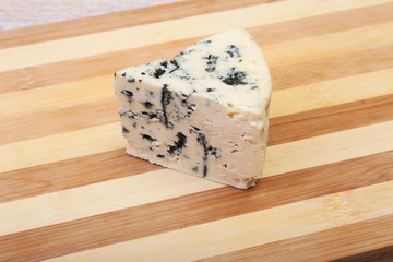 Plate with Tasty blue cheese on wooden table