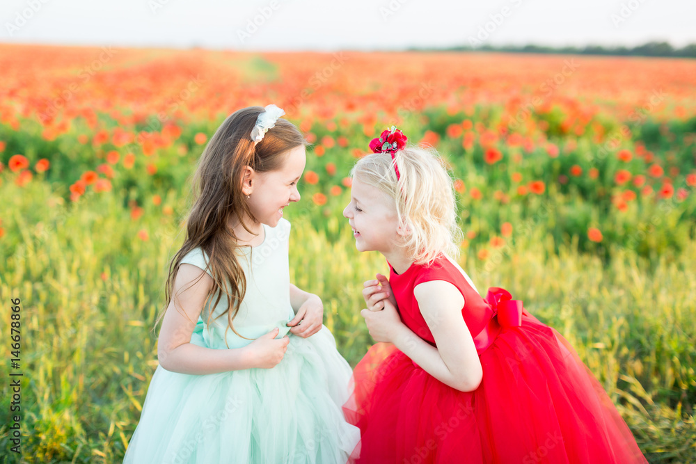 Wall mural girl model, poppies, childhood, fashion, nature and summer concept - two young girlfriend laugh over