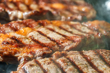 Raw Ribeye Steak with Herbs and Spices, frying on grill pan