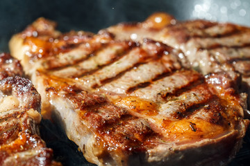 Raw Ribeye Steak with Herbs and Spices, frying on grill pan