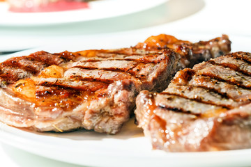 Delicious juicy grilled steaks ribeye on a plate, selective focus, closeup
