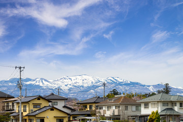 Fototapeta na wymiar japanese house and community of hanamiyama with Azuma-kofuji's Snow-capped mountains range background