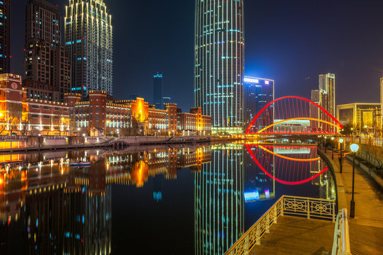 River And Illuminated Modern Buildings Against Sky at night in city of China. © fanjianhua
