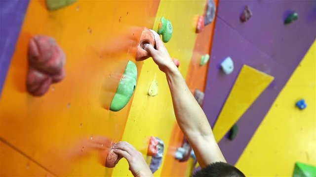 Man Climbing Up On Color Practice Wall Indoor