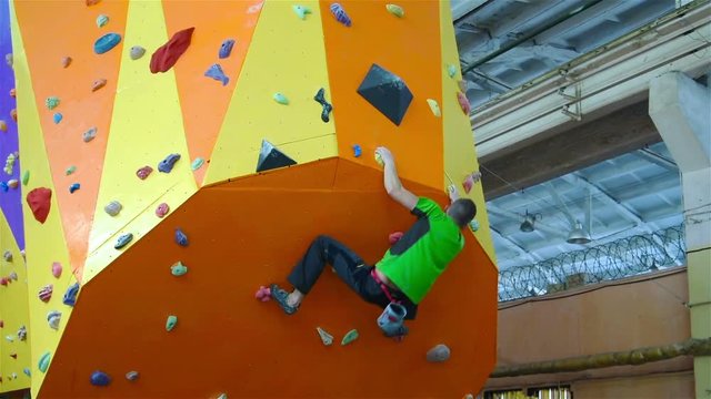 Climber Man On Artificial Climbing Wall In Bouldering Gym Without Insurance. Slow Motion Effect