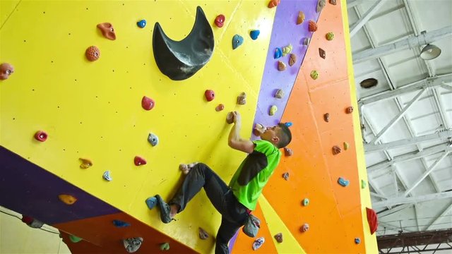 Climber Man On Artificial Climbing Wall In Bouldering Gym