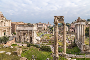 Fototapeta na wymiar Rome, Italy. The ancient ruins of the Roman Forum: the temple of Saturn, the temple of Vespasian, the arch of Septimius Severus