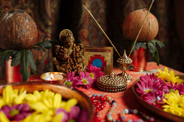 Photo on Buddhist themes. Close-up. Buddha statue, flowers on a tray and a candle