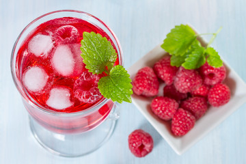 Alcohol cocktail with raspberries and mint