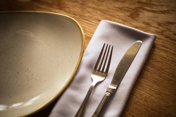 Fork and knife on a table, near a plate