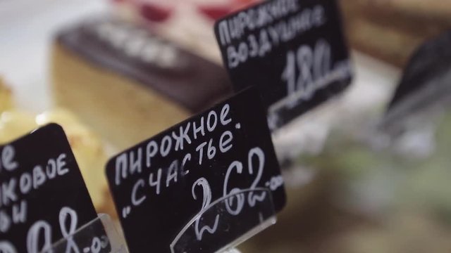 Shelf at a bakery with many different kinds of dessert - cakes, pastries, sweets,tarlets and pies.Wide assortment of fresh pastry at shop window.
