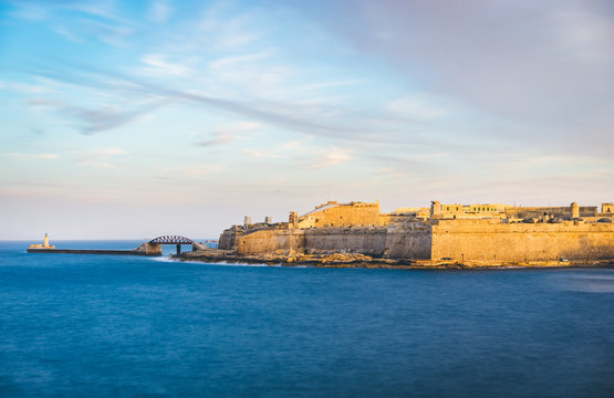 Fort Saint Elmo and Breakwater with the lighthouse at sunset, Valletta, Malta