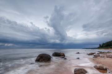 Seascape. Storm clouds gathering over the rocky beach.