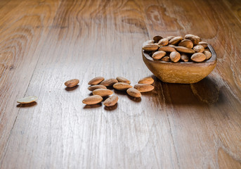 almond from wooden bowl on wooden board