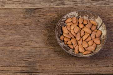 almond in wooden bowl on wooden board