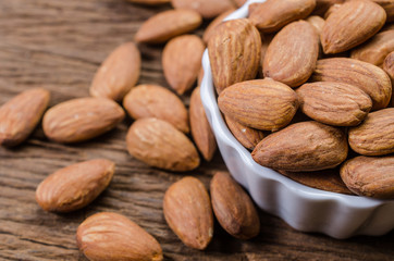 almond in porcelain bowl on wooden board