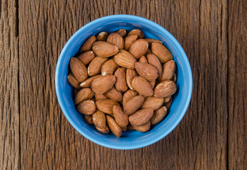 almond in blue porcelain bowl on wooden board