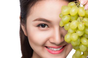 Young beautiful asian woman eating fresh grapes isolated on white background