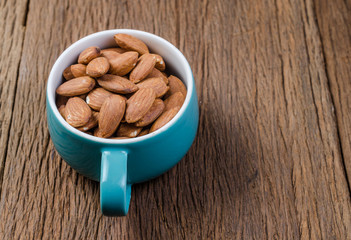 almond in blue porcelain cup on wooden board