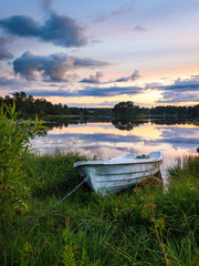 Boot liegt an stillem See im Sonnenuntergang