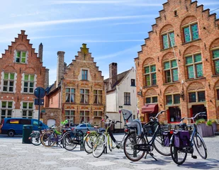 Fototapeten Bicycles are parked in front of historical medieval brick buidlings © Zoegraphy