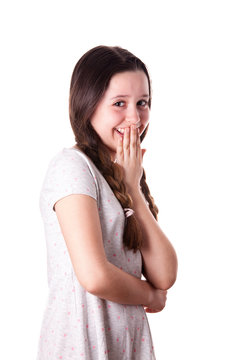 Young teenager girl giggling with her arm in front of mouth over the white background