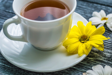 Still life with cup of tea and cake on the wooden background