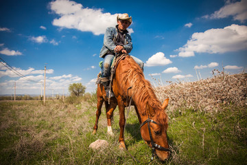 Cowboy riding a horse over the mountains - 146737234