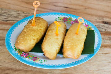 Chinese steamed bun fried with banana leaf in dish on wooden table