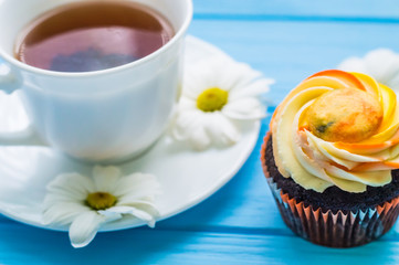 Still life with cup of tea and cake on the wooden background