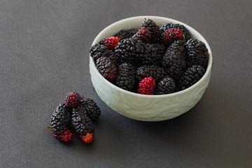 Fresh organic vietnamese mulberry on grey background in green bowl