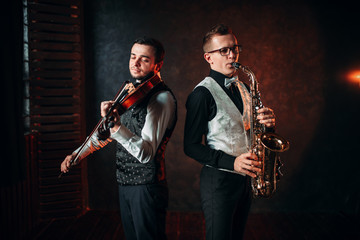 Obraz premium Saxophonist and violinst playing classical melody
