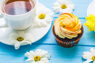 Still life with cup of tea and cake on the wooden background