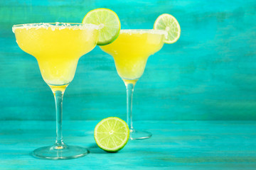 Lemon Margarita cocktails on vibrant turquoise with copyspace