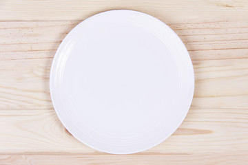 Empty white plate on wooden background