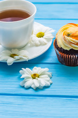 Still life with cup of tea and cake on the wooden background