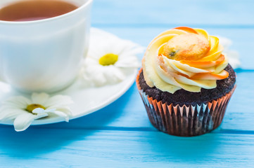 Still life with cup of tea and cake on the wooden background