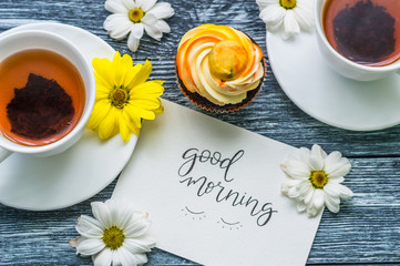 Still life with cup of tea and cake on the wooden background