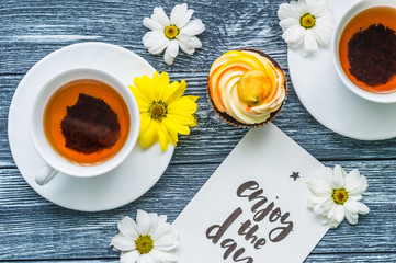 Still life with cup of tea and cake on the wooden background
