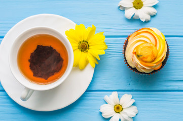 Still life with cup of tea and cake on the wooden background