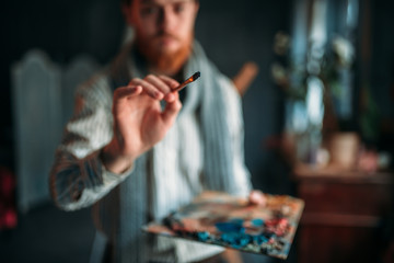 Fototapeta premium Painter with brush in hand selective focus