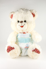 Teddy bear in a diaper on a white background